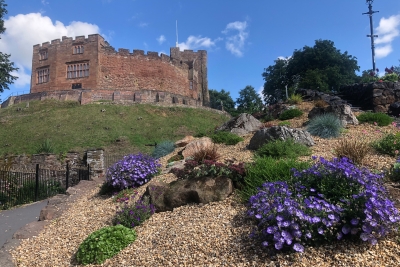 Tamworth Castle behind a flower bed with purple and green flowers